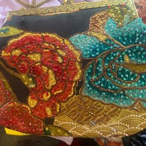 Vintage Christina beautiful glass beads and sequins sewn on black background.